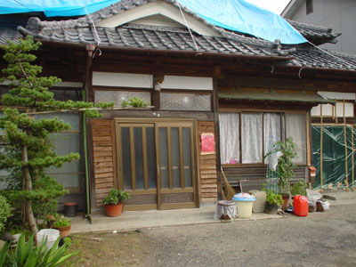 盛土上の家屋が傾いた状態の写真