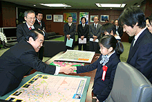 画像：大臣から祝福の握手に少し緊張気味