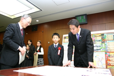 写真：大臣に作品紹介する渡邉君