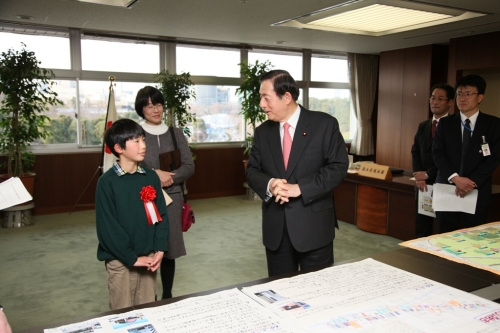 写真:太田国土交通大臣に作品の説明をする町田さん