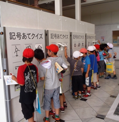 地図記号ボードをめくる子どもたち（写真）