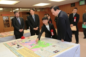 写真:太田国土交通大臣に作品の説明をする柴田さん
