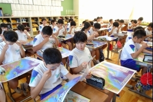 写真：余色立体地図で地形を立体的に見る児童たちの様子