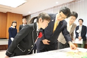 写真:石井国土交通大臣に作品の説明をする荒井さん