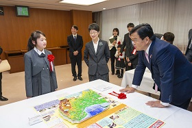 写真:赤羽国土交通大臣に作品の説明をする荒井さん