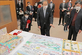 写真:斉藤国土交通大臣に作品の説明をする坂さん